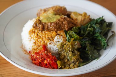 Nasi Padang, Endonezya 'nın Rendang Sosu ile birlikte 29 Haziran 2025' te yakalandı. Geleneksel Minang pirinç yemeği, sebze ve sambal eşliğinde, zengin ve baharatlı rendang sosuyla servis edilir..