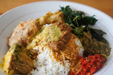 Nasi Padang, Endonezya 'nın Rendang Sosu ile birlikte 29 Haziran 2025' te yakalandı. Geleneksel Minang pirinç yemeği, sebze ve sambal eşliğinde, zengin ve baharatlı rendang sosuyla servis edilir..