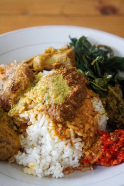 Nasi Padang, Endonezya 'nın Rendang Sosu ile birlikte 29 Haziran 2025' te yakalandı. Geleneksel Minang pirinç yemeği, sebze ve sambal eşliğinde, zengin ve baharatlı rendang sosuyla servis edilir..