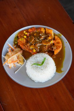 Tavuk Katsu Curry, Endonezya, 4 Temmuz 2025 'te yakalandı. Lezzetli ve rahatlatıcı bir yemek için Japon usulü köri soslu kızarmış tavuk ve pilav..