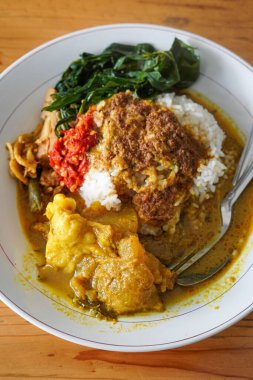 Nasi Padang Kikil, Endonezya, 13 Temmuz 2025 'te yakalandı. Baharatlı Padang usulü biftek tendonuyla servis edilen pilav köri, sebze, sambal ve kalın Minang tadı için zengin hindistan cevizi sosu.