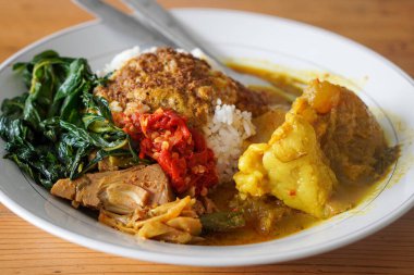 Nasi Padang Kikil, Endonezya, 13 Temmuz 2025 'te yakalandı. Baharatlı Padang usulü biftek tendonuyla servis edilen pilav köri, sebze, sambal ve kalın Minang tadı için zengin hindistan cevizi sosu.