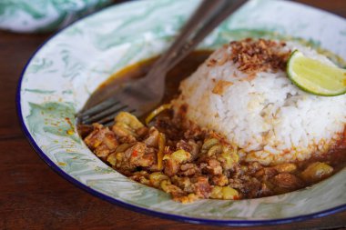 Gultik, Endonezya, 18 Temmuz 2025 'te yakalandı. Küçük pirinç porsiyonu sığır gülü, zengin hindistan cevizi körisi ve sambal, popüler Jakarta sokak yemekleri.