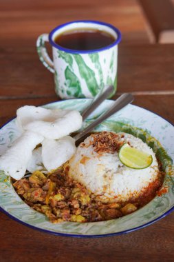 Gultik, Endonezya, 18 Temmuz 2025 'te yakalandı. Küçük pirinç porsiyonu sığır gülü, zengin hindistan cevizi körisi ve sambal, popüler Jakarta sokak yemekleri.