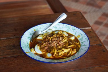 Lontong kari ayam, Endonezya, 2 Ağustos 2025 'te yakalandı. Baharatlı tavuk, hindistan cevizi çorbası ve geleneksel Endonezya kahvaltısı favorisi aromalı otlarla servis edilen pirinç kekleri..