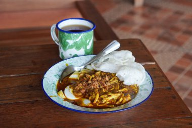 Lontong kari ayam, Endonezya, 2 Ağustos 2025 'te yakalandı. Baharatlı tavuk, hindistan cevizi çorbası ve geleneksel Endonezya kahvaltısı favorisi aromalı otlarla servis edilen pirinç kekleri..