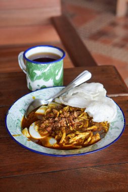 Lontong kari ayam, Endonezya, 2 Ağustos 2025 'te yakalandı. Baharatlı tavuk, hindistan cevizi çorbası ve geleneksel Endonezya kahvaltısı favorisi aromalı otlarla servis edilen pirinç kekleri..
