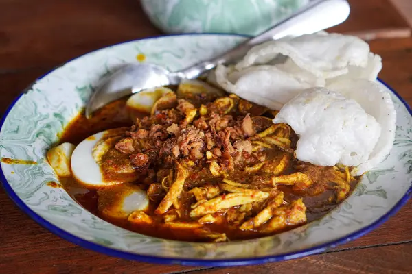 Lontong kari ayam, Endonezya, 2 Ağustos 2025 'te yakalandı. Baharatlı tavuk, hindistan cevizi çorbası ve geleneksel Endonezya kahvaltısı favorisi aromalı otlarla servis edilen pirinç kekleri..