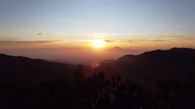 Sikunir Golden Sunrise, İHA tarafından 23 Ağustos 2025 'te yakalandı. Sisli Dieng dağlarının üzerinde yükselen altın güneşin havadan görünüşü, sıcak ışık kayan tepeleri ve dağ zirvelerini aydınlatıyor, nefes kesici manzara.