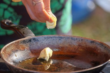 Elleri kızartma tavasına margarin koyuyor. Yemek pişiren insanların görüntüsü. Paslı tava