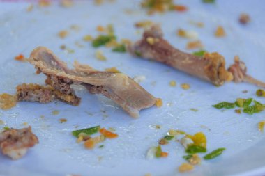 Beyaz tabakta kalan tavuk kemikleri. Tavuk kemiklerinin soyut şekli.