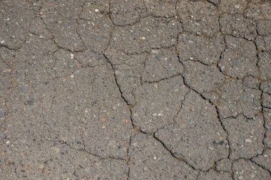 Çatlamış asfalt yolların soyut şekilleri, desenleri ve dokuları. Siyah asfalt yolda hasar var. Grafik tasarımı veya afiş arkaplanı için. Arkaplan ve doku konsepti