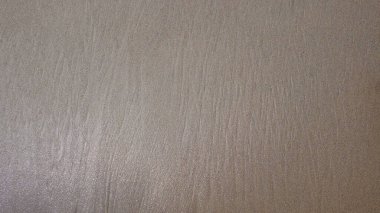 Islak kumsalın soyut şekilleri, desenleri ve dokuları. Deniz dalgaları yüzünden kumsal kumu hâlâ ıslak. Grafik tasarımı veya afiş arkaplanı için. Doğal desen ve doku arkaplanı