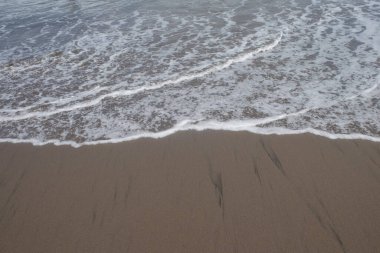 Kumsaldaki dalgaların kıvrımlı şekli. Kum ve deniz dalgalarının şekilleri, desenleri ve dokuları. grafik tasarım ve afiş arkaplanları için