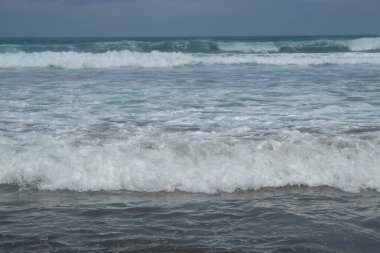 Kumsaldaki dalgaların soyut şekilleri, desenleri ve dokuları. Kumsalda dalgaların hareketi. grafik tasarım ve afiş arkaplanları için.