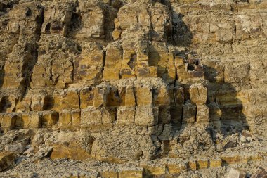 Kireçtaşı yüzeyinin soyut şekilleri, desenleri ve dokuları katmanlanmış gibi görünüyor. Gölün kenarındaki kireçtaşı duvar. Kireç taşının yüzeyindeki doğal süsleme şekilleri. Grafik tasarımı veya afiş arkaplanı için