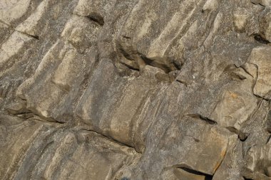 Kireçtaşı yüzeyinin soyut şekilleri, desenleri ve dokuları katmanlanmış gibi görünüyor. Gölün kenarındaki kireçtaşı duvar. Kireç taşının yüzeyindeki doğal süsleme şekilleri. Grafik tasarımı veya afiş arkaplanı için