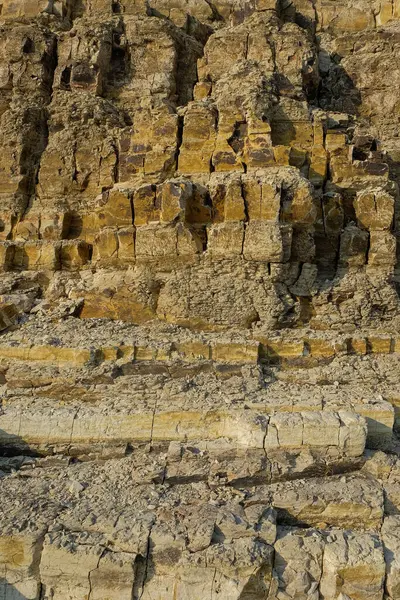 Kireçtaşı yüzeyinin soyut şekilleri, desenleri ve dokuları katmanlanmış gibi görünüyor. Gölün kenarındaki kireçtaşı duvar. Kireç taşının yüzeyindeki doğal süsleme şekilleri. Grafik tasarımı veya afiş arkaplanı için