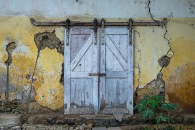 Eski ahşap ve çatlak duvarlardan gelen sürgülü kapının eşsiz şekli eski bir izlenim veriyor. Terk edilmiş bir tren istasyonu deposunda büyük ahşap bir kapı.