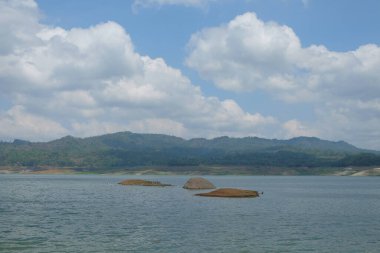 A small plain in the middle of the reservoir. A small hill appears in the middle of the reservoir because the water flow decreases in the dry season clipart