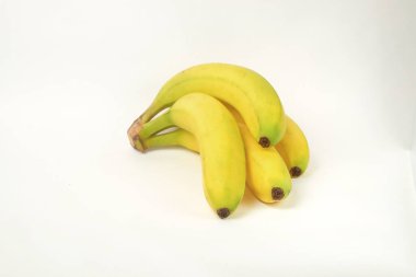 Beyaz arka planda izole edilmiş bir grup olgun sarı muz. Muz A vitamini kaynağıdır. Grafik tasarımı veya reklam pankartları için