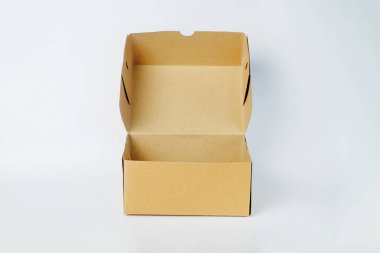 Beyaz arka planda izole edilmiş kahverengi bir karton kutu. Kare şeklinde atıştırma kutusu. Model tasarımı için sade karton kutu