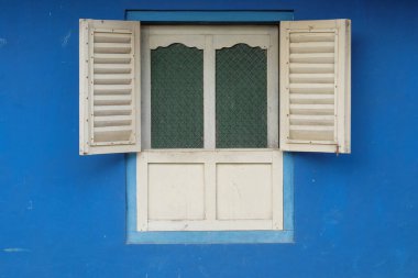 Beyaz boyalı ahşap pencere ve mavi duvar arkası. Pencereyi aç. Pankart arkaplanı veya grafik tasarımı için minimalist şekil