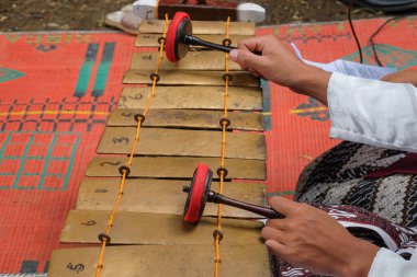 Geleneksel Cava müzik enstrümanları Gamelan olarak adlandırılır. Gamelan müzik enstrümanları çalarken ellerim kapalı. Tipik Cava müzik aleti, Endonezya