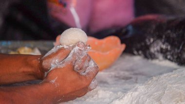 Donut hamuru yapmak için ellerinizi yakın tutun. Satılık donut yapma süreci.