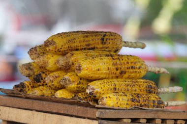 A pile of roasted corn sold on the street. Grilled corn with sweet and savory taste. Abstract shapes, patterns and textures clipart