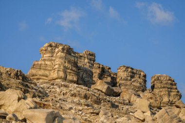 Sütunlar ve duvarlar gibi kireçtaşı yapılar. Kireçtaşı kayalarının şekli, şekli ve dokusu. Mavi gökyüzündeki kireçtaşı kayaları. Grafik tasarımı için doğal taş deseni ve doku arkaplanı.