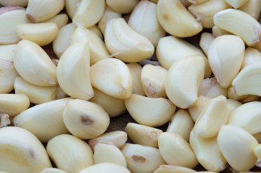 Soyut desen ve soyulmuş sarımsak yığını. Baharat pişirmek için sarımsak. Kokulu ve taze bir koku. Grafik tasarımı için doğal desen ve doku arka planı. Tarım ve ticaret endüstrisi maddeleriyle ilgili