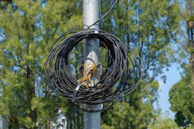 Siyah elektrik kabloları bir karmaşanın içinde. Sokak lambası direklerinden sarkan elektrik kabloları