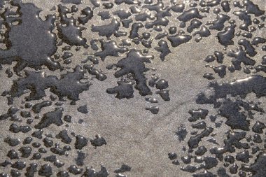 Yerdeki su damlacıklarının soyut şekilleri, desenleri ve dokuları. Grafik tasarımı için boşluk kopyala. Arka plan Doğal desenler ve dokular. Yerler ıslak.