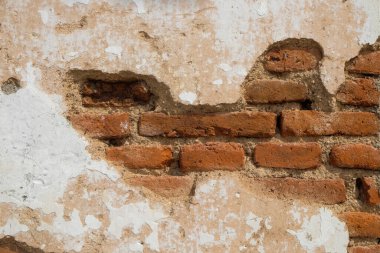 Hasarlı eski kırmızı tuğla duvarın şekli, şekli ve yüzey dokusu klasik bir izlenim veriyor. Eski duvar soyuluyor ve inliyor. Doğal desenlerin ve eski duvarların dokularının arka planı. Uzayı kopyala Soyut grafik tasarımı