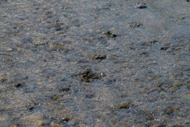 Net nehir suyunun soyut şekilleri, desenleri ve dokuları doğal kayalarla dalgalanır. Yukarıdan görünen küçük nehir kayaları. Çevresel konsept. Doğal su, kaya deseni ve doku arka planı. Grafik tasarımı veya afiş arkaplanı için