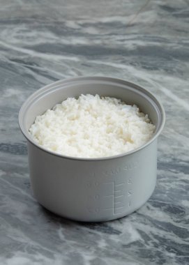 Pilav tenceresinde pilav pişirdim. Karbonhidrat kaynakları kavramı. Temiz beyaz pirinç. Mermer masa arka planı. Metin için alanı kopyala. Grafik tasarımı veya afiş arkaplanı için alanı kopyala