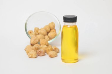 Sarı şamdan yağını bir şişeye koy ve beyaz bir zemin üzerine izole edilmiş bir yığın şamdan çekirdeği. Bitkisel ilaç ve baharat kavramı. Cam bir kapta mum çekirdeği yığını. Metin için yer kopyala. Tasarım veya afiş arka planı için.