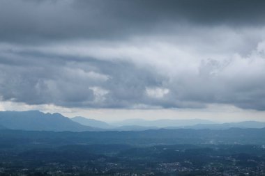 Vadilerin ve tepelerin üzerinde soyut dokuya sahip dramatik koyu mavi bulutlar. Tepelerin doğal görünümü. İklim ve hava konsepti. Grafik tasarımı veya afiş arkaplanı için.