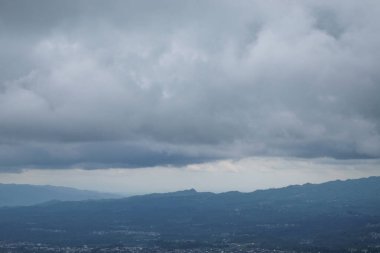 Vadilerin ve tepelerin üzerinde soyut dokuya sahip dramatik koyu mavi bulutlar. Tepelerin doğal görünümü. İklim ve hava konsepti. Grafik tasarımı veya afiş arkaplanı için.