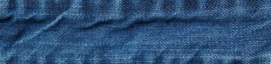 Kırışık mavi kot kumaşın soyut doku arka planı. Kotun yüzeyi. Doğal desen ve doku. Grafik tasarımı veya afiş arkaplanı için.