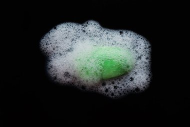 Yeşil banyo sabunu ve köpük izole edilmiş siyah arka plan. Vücut bakımı ve sağlık konsepti. Beyaz köpük dokusu. Grafik tasarımları veya afiş arkaplanları için