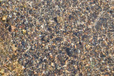 Üst manzara deseni ve berrak su dalgalanmalarının dokusu. Doğal dokulu arka plan. Görünür nehir yatağı kayalar. Grafik tasarımı veya afiş arkaplanı için