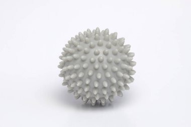 Beyaz arka planda izole edilmiş gri bir masaj topunu kapat. Sinir refleksi eğitimi için bir araç. Limanlar ve sağlık ekipmanları konsepti. Ders için alanı kopyala.