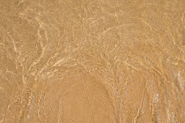 Arkaplan deseni ve deniz suyunun dokusu beyaz kumda dalgalanır. Temiz beyaz kumlu bir sahil. Uzayı metin için kopyala. Grafik tasarımı için, 3B görüntüleme ve pankart arkaplanı