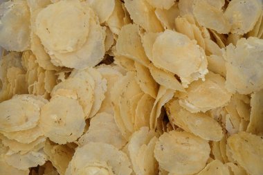 Soyut desenleri ve dokuları olan kızarmamış cips yığını. Gnetum gnemon tohumlarından yapılan geleneksel Endonezya gıda cipsleri. Yiyecek endüstrisi konsepti. Grafik tasarımı için, 3B görüntüleme ve pankart arkaplanı