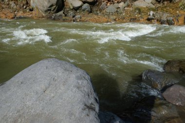 Dağ nehrinin kıyısındaki büyük kayalar. Ürün yerleştirme tasarımı için. Rahatlamak için sakin ve huzurlu bir ortam. Grafik tasarımı, pankart arkaplanı ve 3B oluşturma için