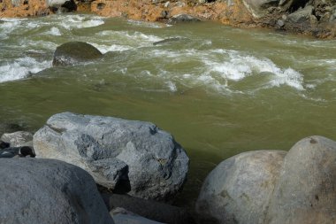 Dağ nehrinin kıyısındaki büyük kayalar. Ürün yerleştirme tasarımı için. Rahatlamak için sakin ve huzurlu bir ortam. Grafik tasarımı, pankart arkaplanı ve 3B oluşturma için