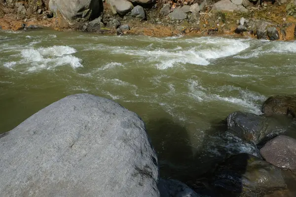 Dağ nehrinin kıyısındaki büyük kayalar. Ürün yerleştirme tasarımı için. Rahatlamak için sakin ve huzurlu bir ortam. Grafik tasarımı, pankart arkaplanı ve 3B oluşturma için