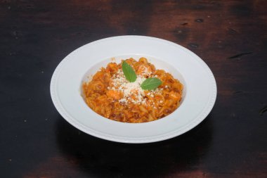 Eski ahşap bir masada fesleğen yapraklarıyla süslenmiş bir tabak makarnayı kapat. Uzayı metin için kopyala. Grafik tasarımı için, 3B görüntüleme ve pankart arkaplanı